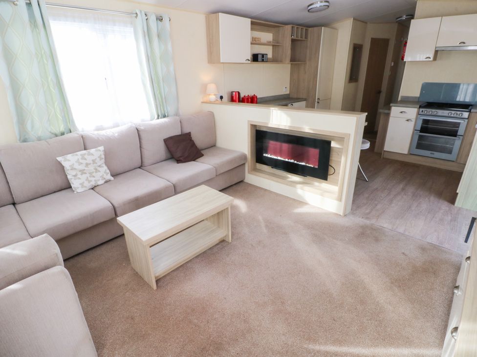 A living room with a sofa and coffee table at Under cliff caravan in Ferryside