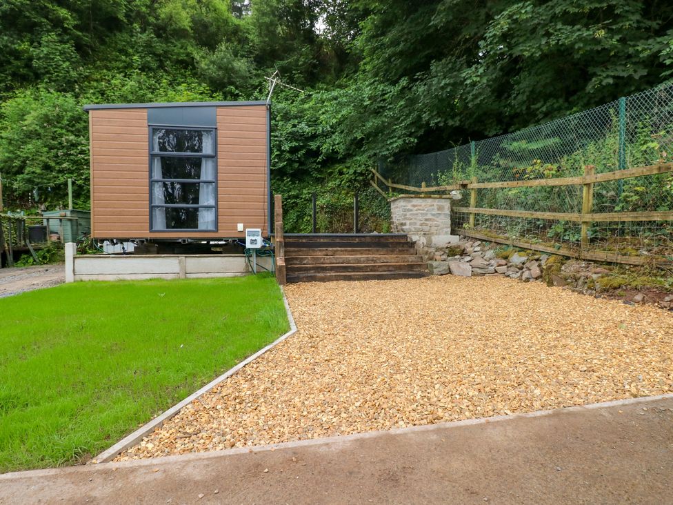 An outdoor view of a mobile cabin with gravel and steps at The Pod in Ferryside