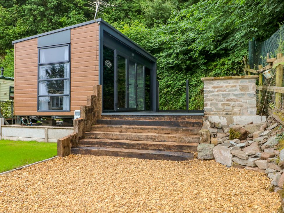 An outdoor view of a modern building with steps and gravel at The Pod in Ferryside