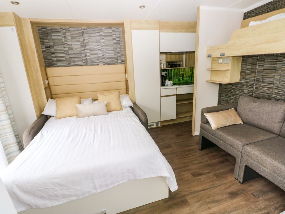 A living room with a bed and sofa at The Pod in Ferryside