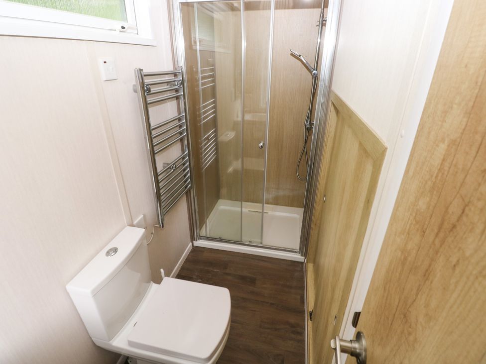 A bathroom with a shower and toilet at The Pod in Ferryside