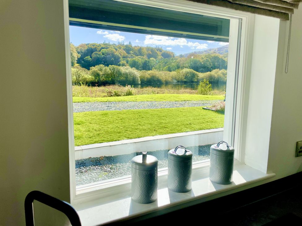 A window with canisters overlooking a grassy area at The Dove Cot in Ambleside