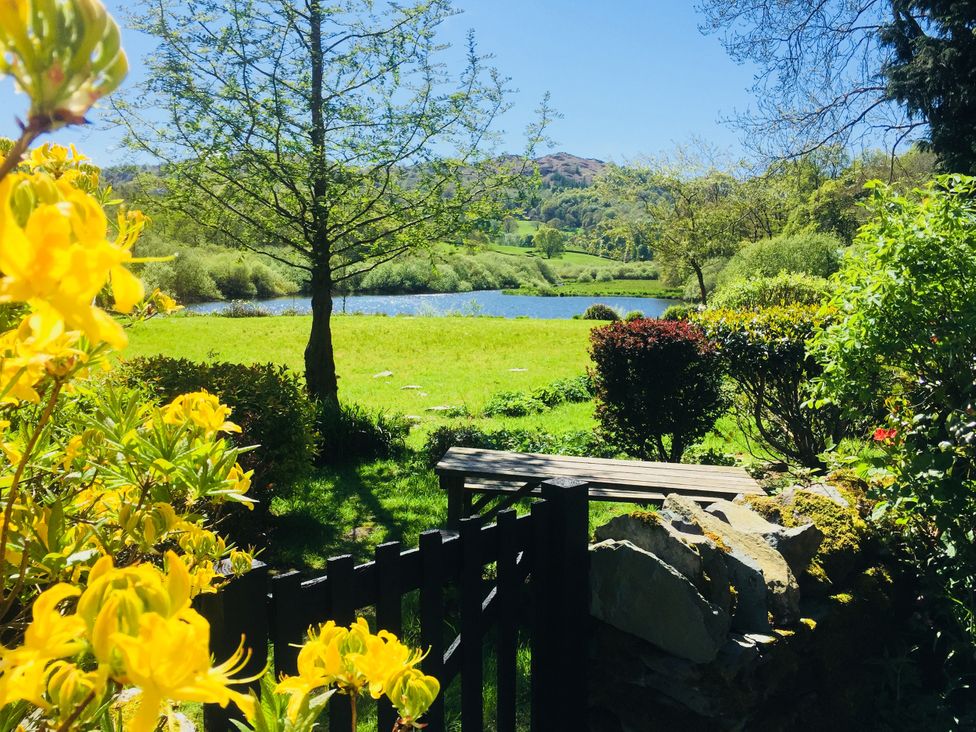 A garden with a view of a lake and flowers at The Dove Cot in Ambleside