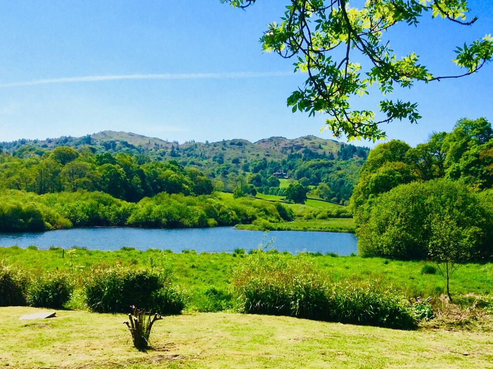 A view of a lake surrounded by hills and trees at The Dove Cot in Ambleside