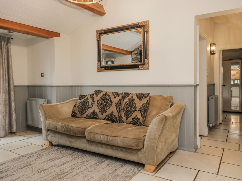 A living room featuring a sofa and a mirror at The Dove Cot in Ambleside