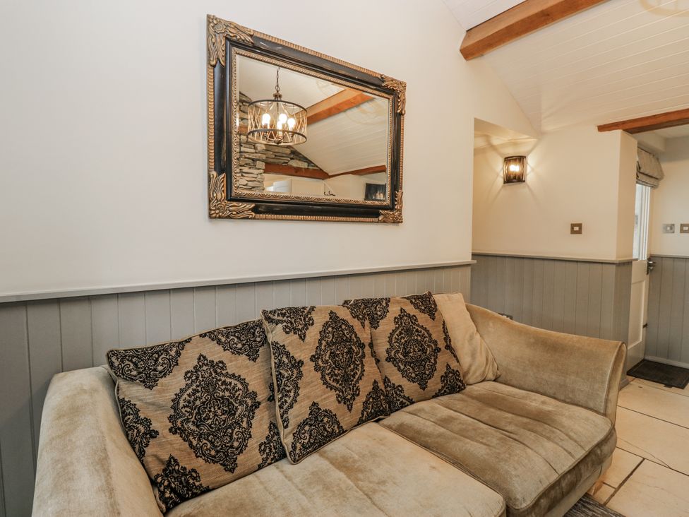 A living room with a sofa and mirror at The Dove Cot in Ambleside