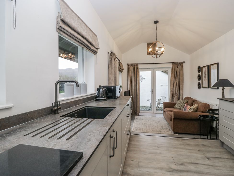 A kitchen with a countertop, sink, and a sofa at The Dove Cot in Ambleside