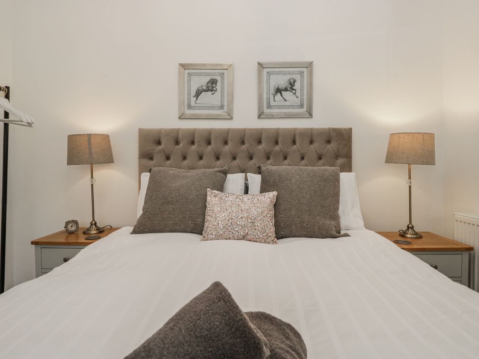 A bedroom with a bed and bedside tables at The Dove Cot in Ambleside