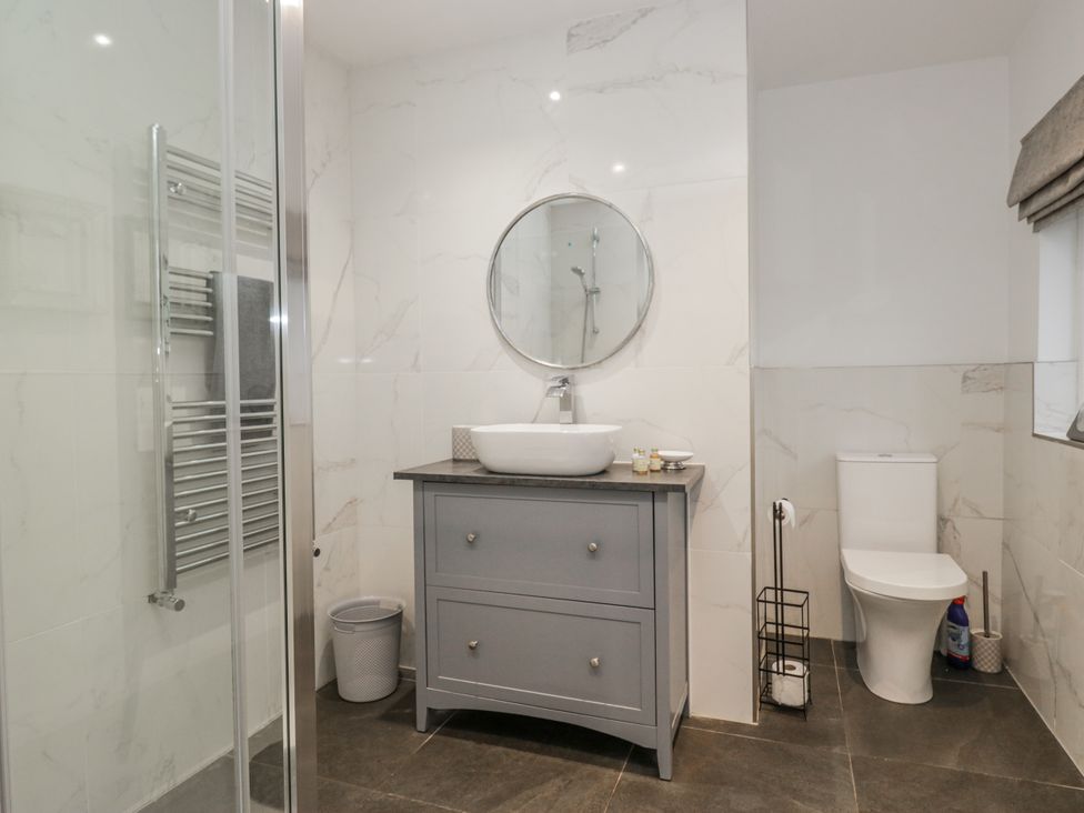 A bathroom with a shower, sink, and toilet at The Dove Cot in Ambleside