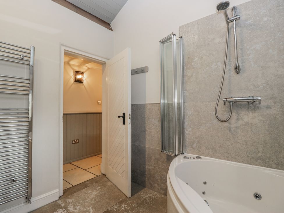 A bathroom featuring a bathtub and shower at The Dove Cot in Ambleside