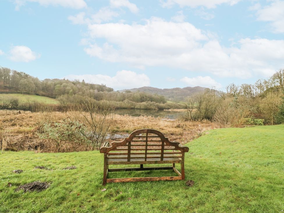 A bench overlooking a lake and hills at The Dove Cot in Ambleside