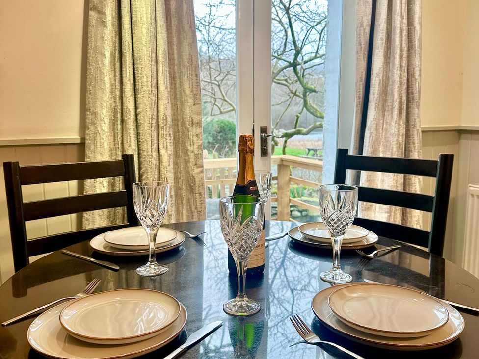 A dining room with a table set for four at The Dove Cot in Clappersgate near Ambleside