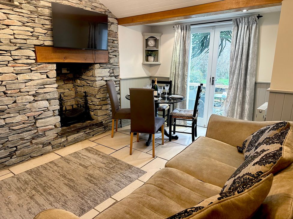 A living room with a sofa and dining area at The Dove Cot in Clappersgate near Ambleside