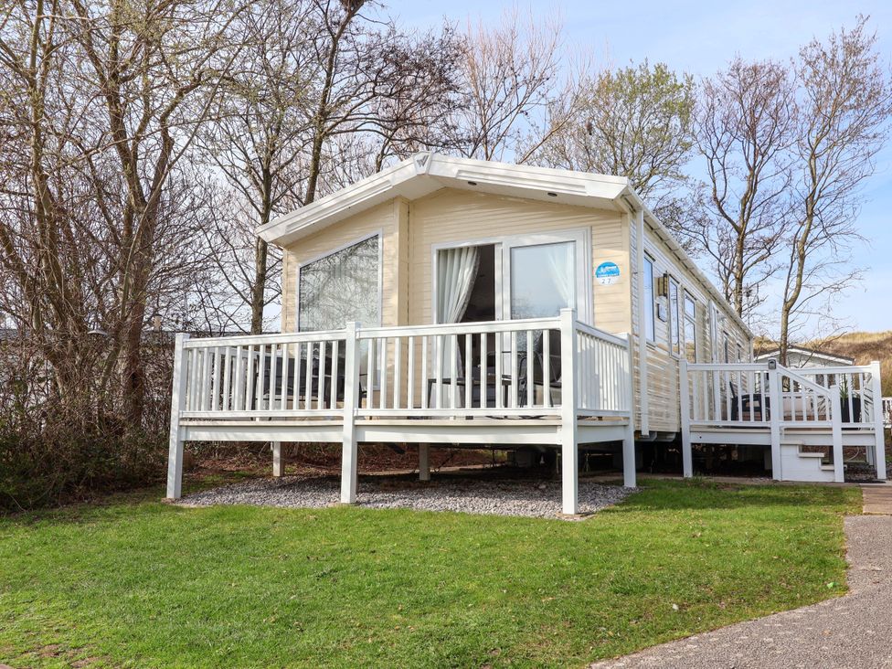 A mobile home with decking and steps at Presthaven Sands in Prestatyn