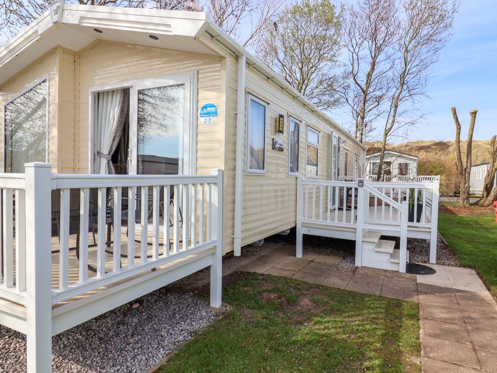 A mobile home with a deck and steps at Presthaven Sands in Prestatyn