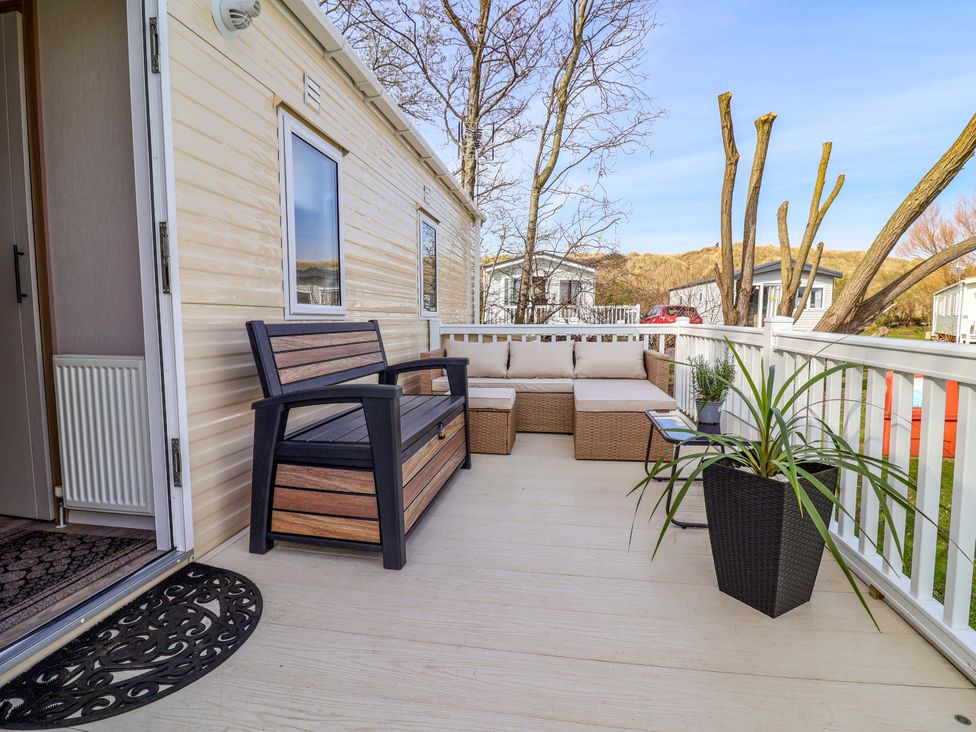 An outdoor area with a sofa and bench at Presthaven Sands in Prestatyn