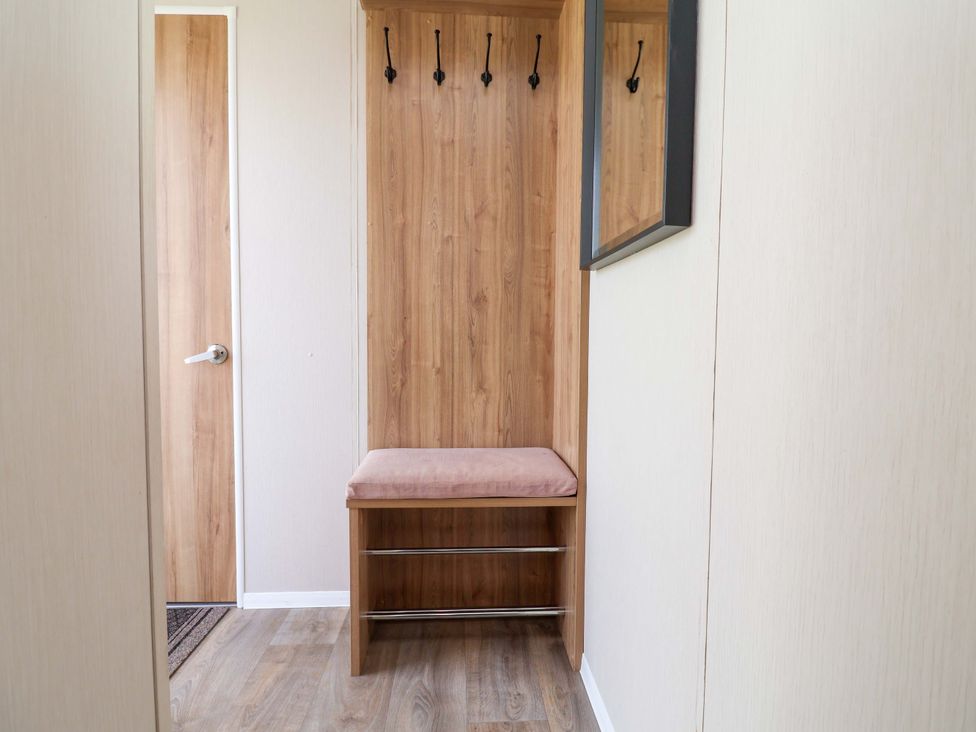 A hallway with coat hooks and a bench at Presthaven Sands in Prestatyn