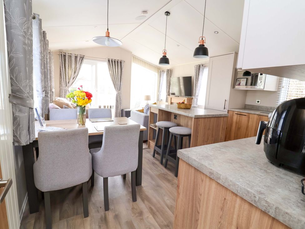 A living room with a table and chairs at Presthaven Sands in Prestatyn