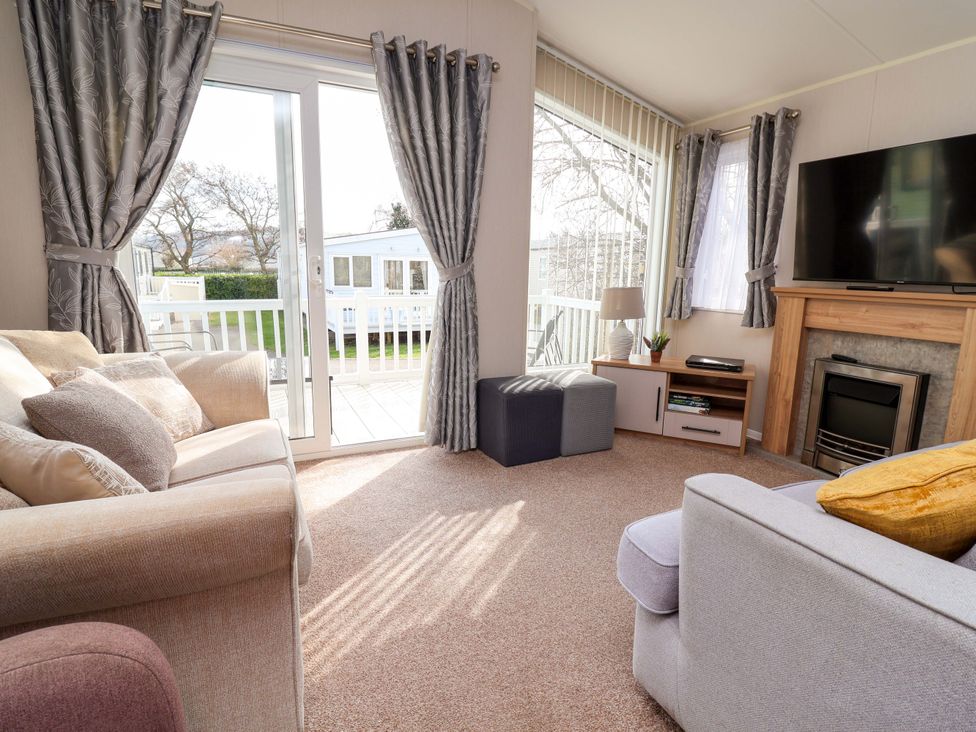 A living room with a sofa and television at Presthaven Sands in Prestatyn