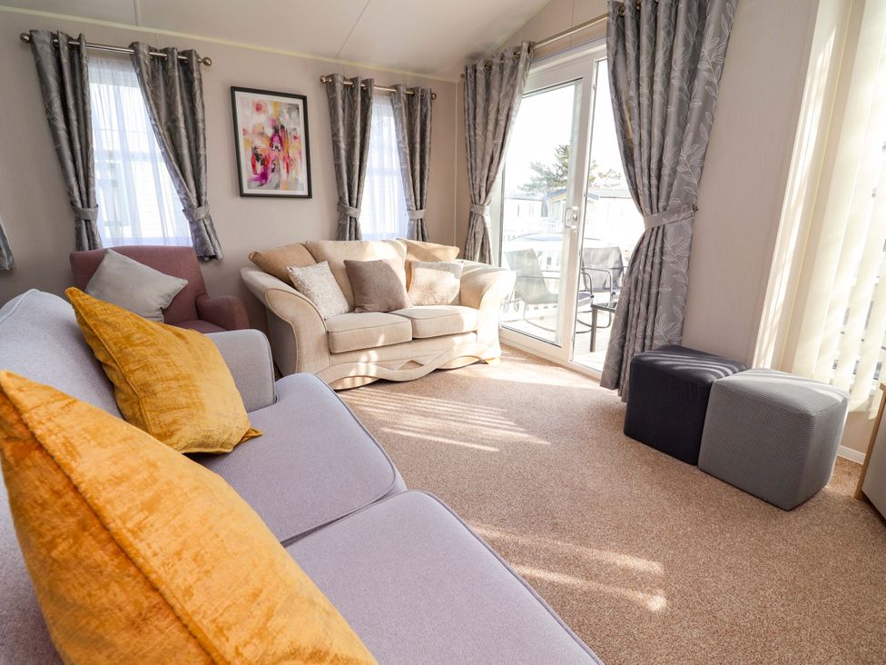 A living room with a sofa and an armchair at Presthaven Sands in Prestatyn