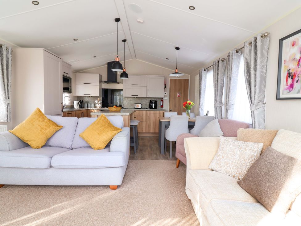 A living room with sofas and a dining area at Presthaven Sands in Prestatyn