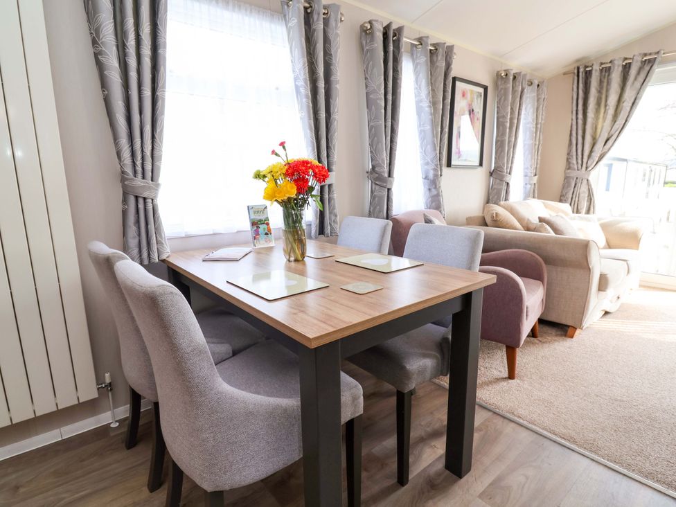 A dining room with a table and chairs at Presthaven Sands in Prestatyn