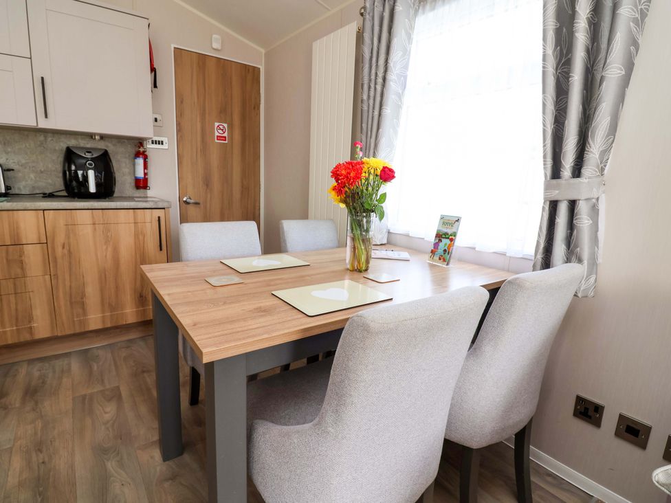 A dining room with a table and four chairs at Presthaven Sands in Prestatyn