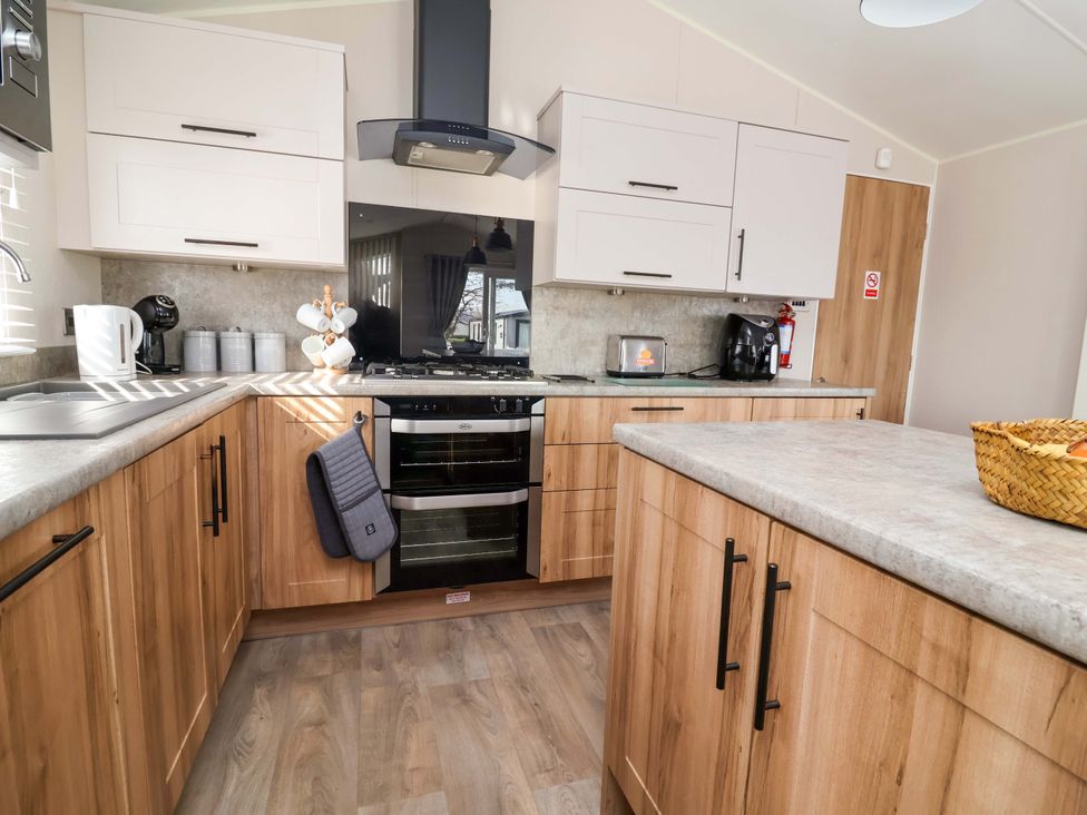 A kitchen with cabinets and appliances at Presthaven Sands in Prestatyn
