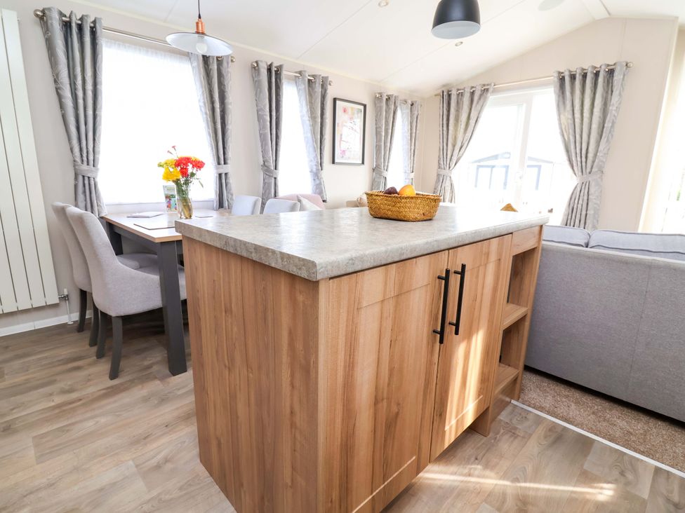 A kitchen with a dining table and chairs at Presthaven Sands in Prestatyn