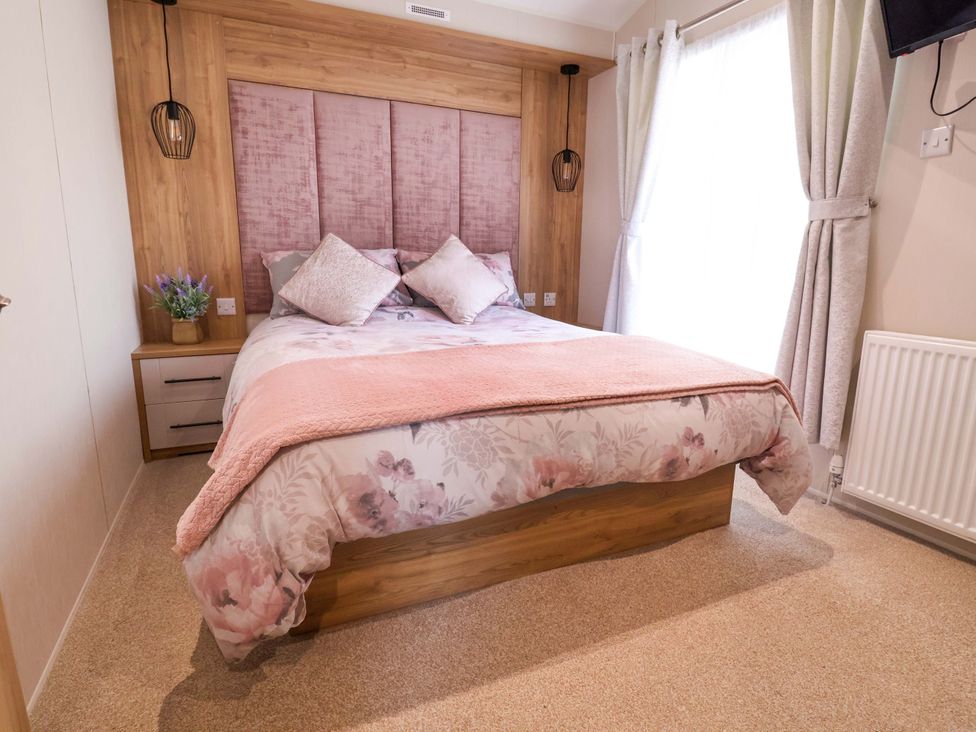A bedroom with a bed and bedside table at Presthaven Sands in Prestatyn
