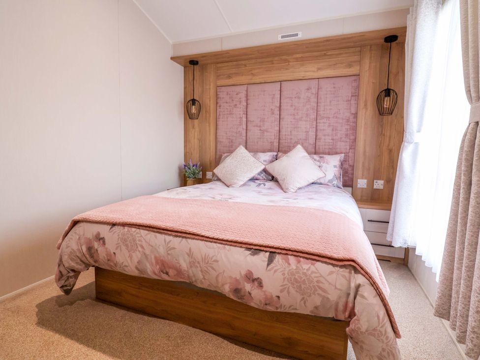 A bedroom with a bed and bedside table at Presthaven Sands in Prestatyn