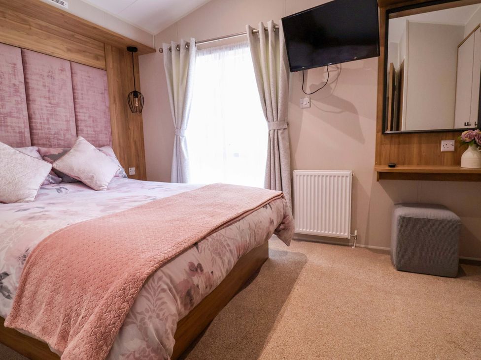 A bedroom with a bed and television at Presthaven Sands in Prestatyn