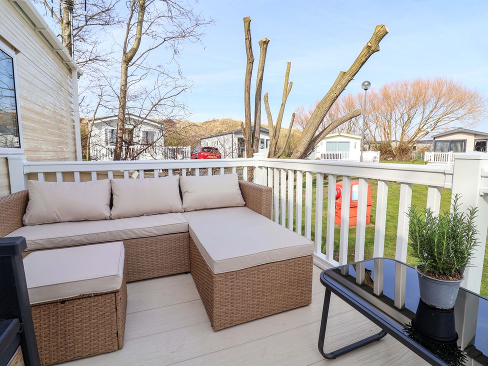 An outdoor seating area with a sofa and table at Presthaven Sands in Prestatyn