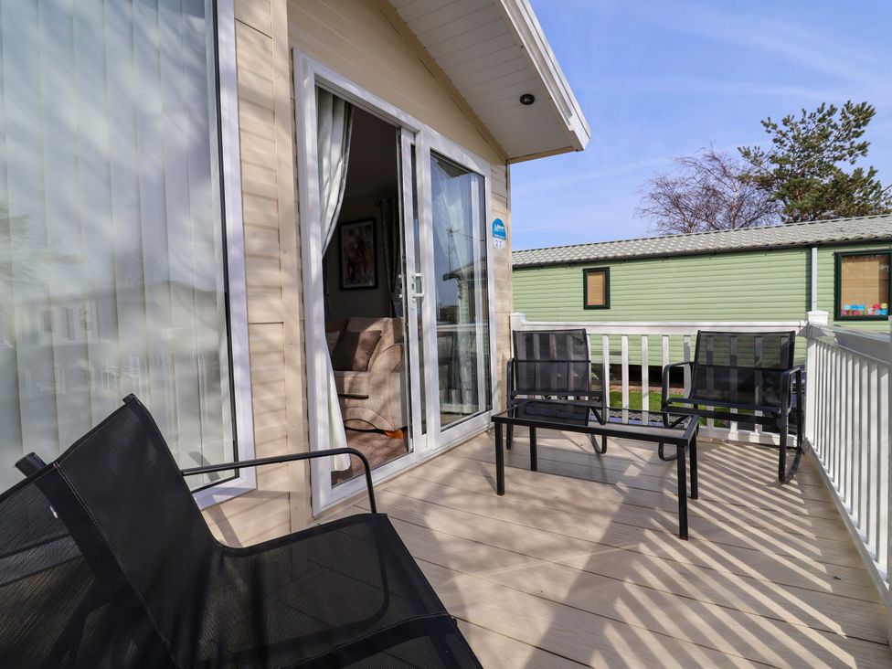 An outdoor area with chairs and a table at Presthaven Sands in Prestatyn