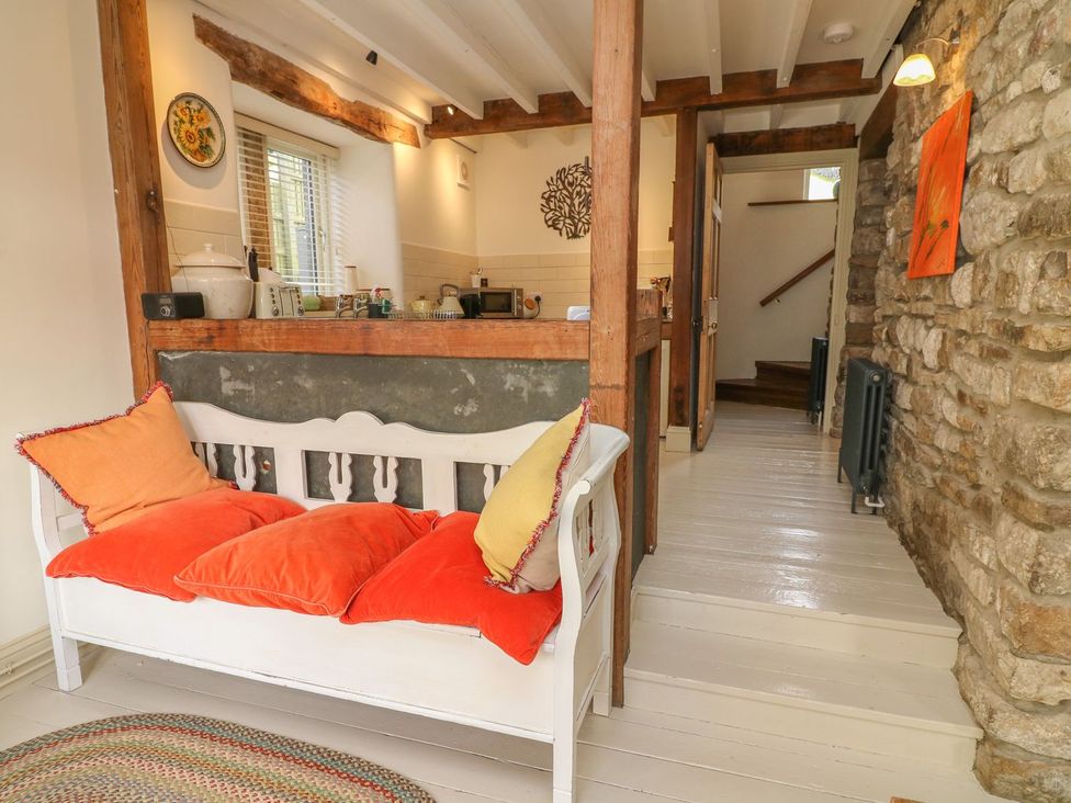 A living room with a sofa and kitchen area at Litton Hall Barn Cottage Skipton