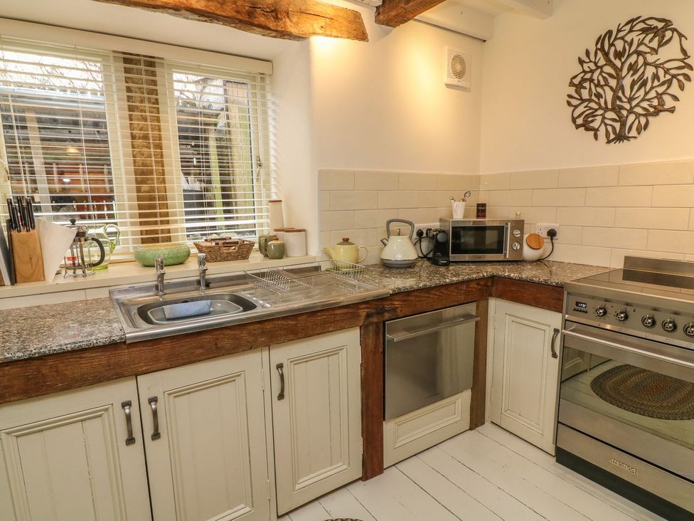 A kitchen with a sink and oven at Litton Hall Barn Cottage in Skipton