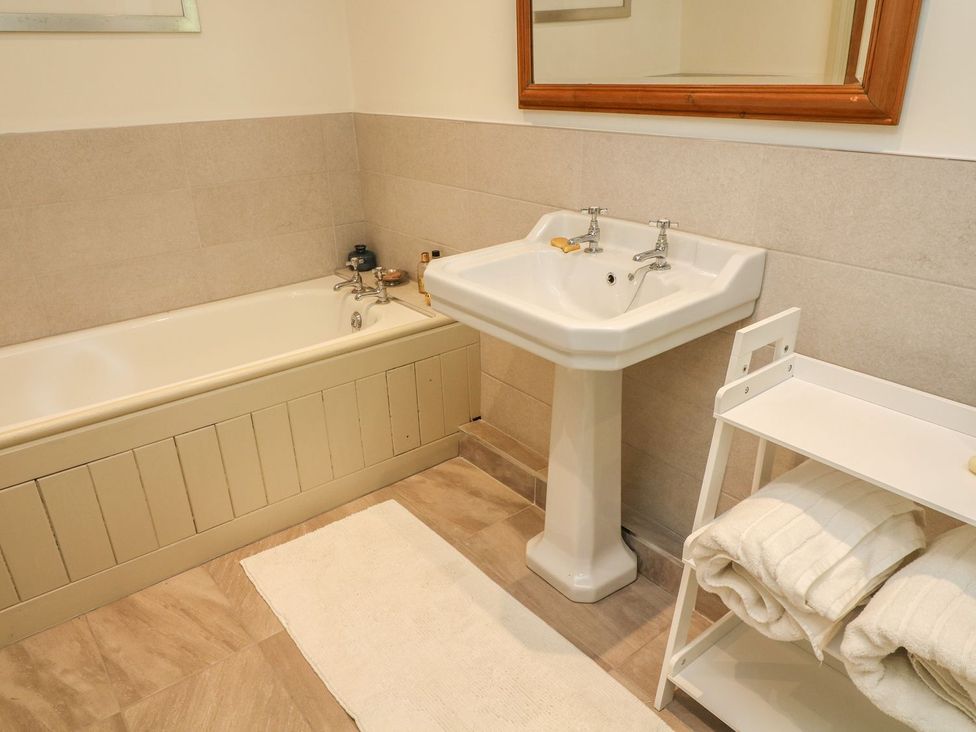 A bathroom with a bathtub and sink at Litton Hall Barn Cottage in Skipton