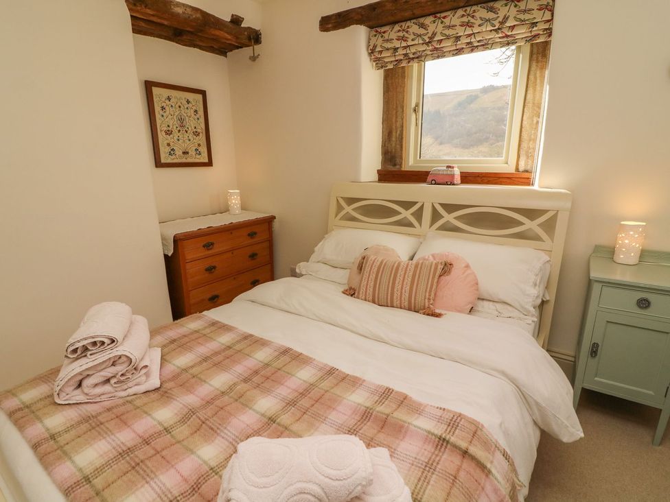 A bedroom with a bed and dresser at Litton Hall Barn Cottage Skipton