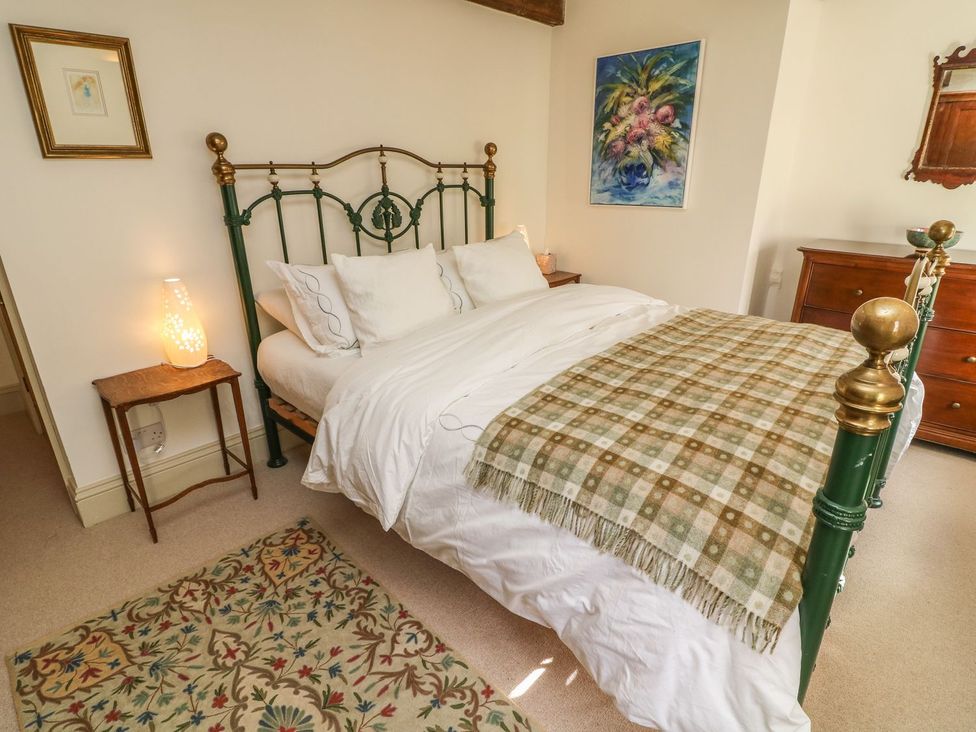 A bedroom with a bed and a bedside table at Litton Hall Barn Cottage Skipton