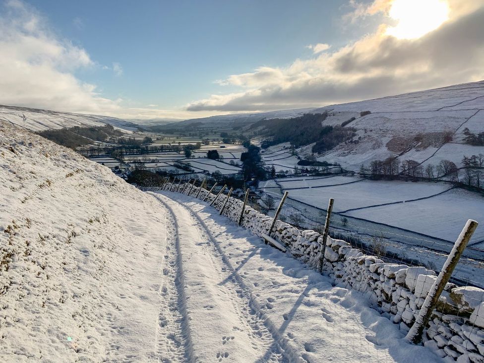 A pathway covered in snow leading through fields at Litton Hall Barn Cottage, Skipton