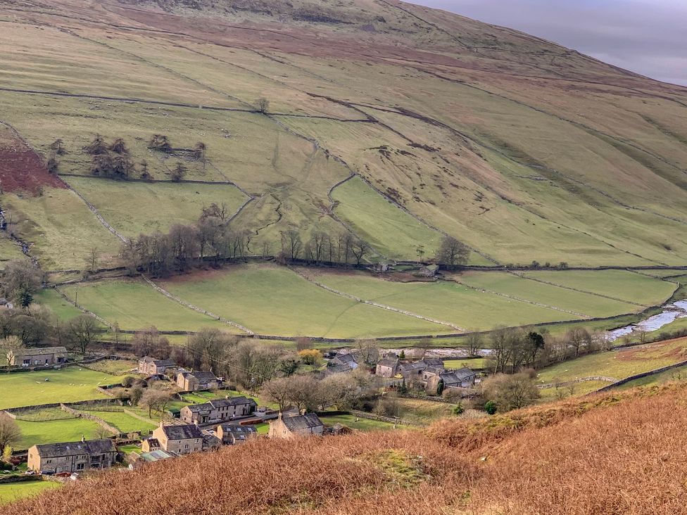 A view of fields and houses near a river at Litton Hall Barn Cottage, Skipton