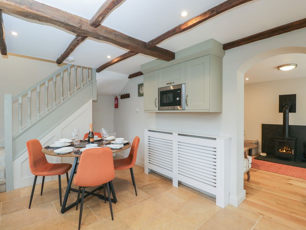 A kitchen with a dining table and staircase at Paddock View Stow-On-The-Wold