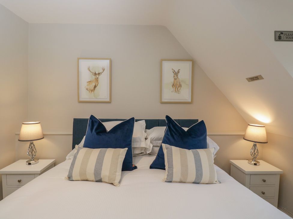 A bedroom with a bed and wall art at Paddock View in Stow-On-The-Wold