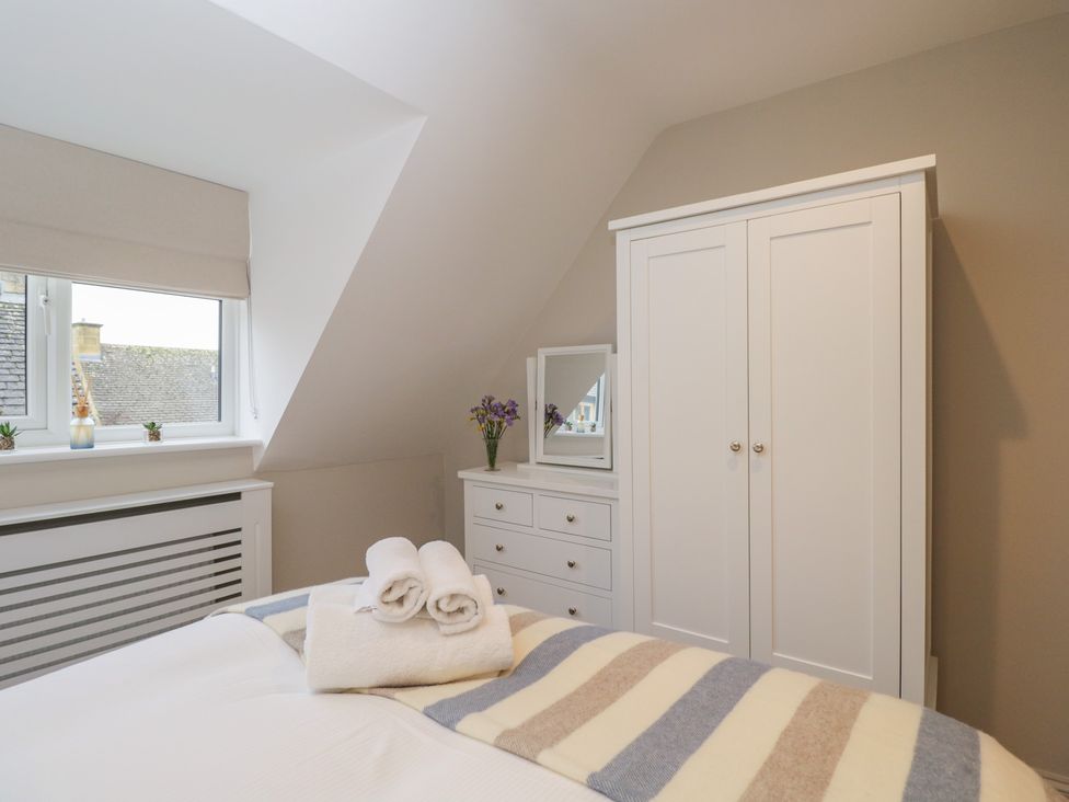 A bedroom with a bed and wardrobe at Paddock View Stow-On-The-Wold