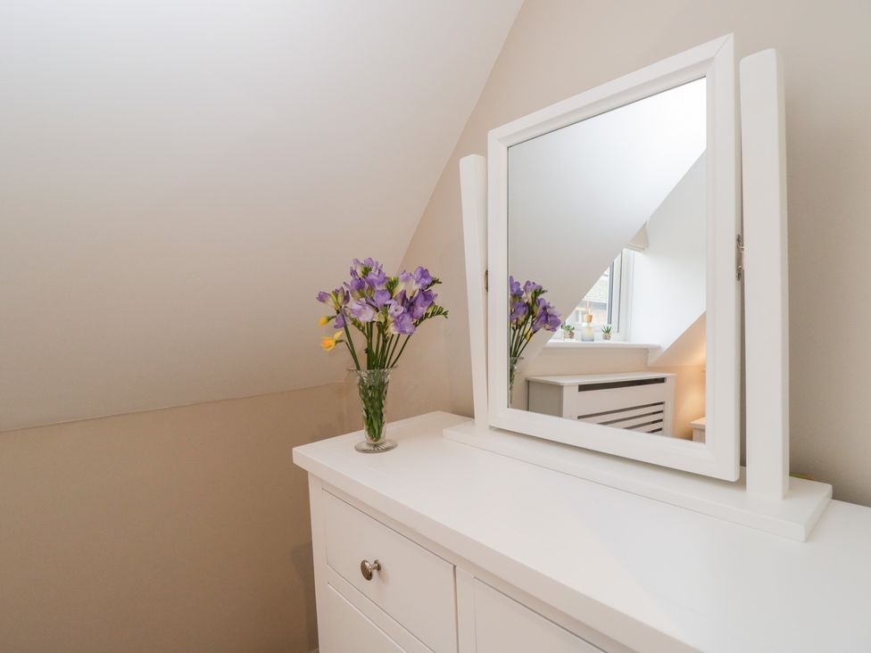 A mirror with flowers on a unit at Paddock View in Stow-On-The-Wold