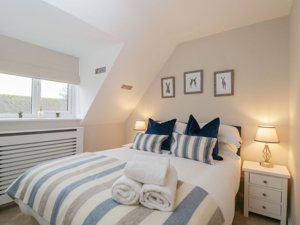 A bedroom with a bed and side table at Paddock View Stow-On-The-Wold