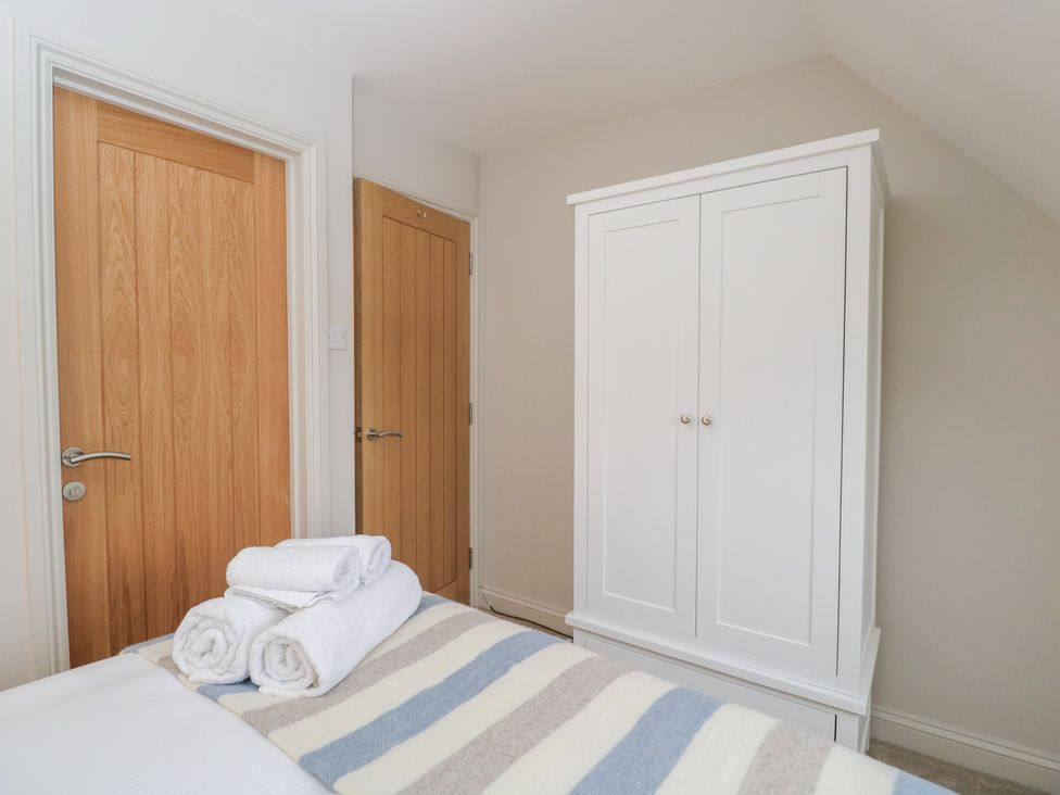 A bedroom with a wardrobe and towels at Paddock View in Stow-On-The-Wold