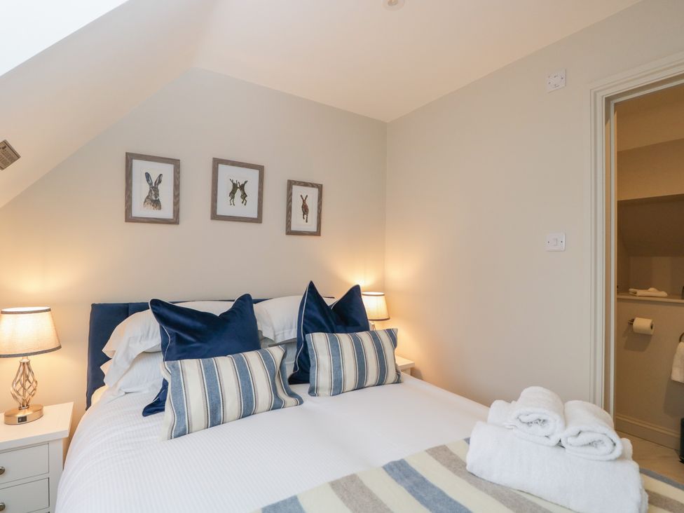 A bedroom with a bed and pictures on the wall at Paddock View in Stow-On-The-Wold