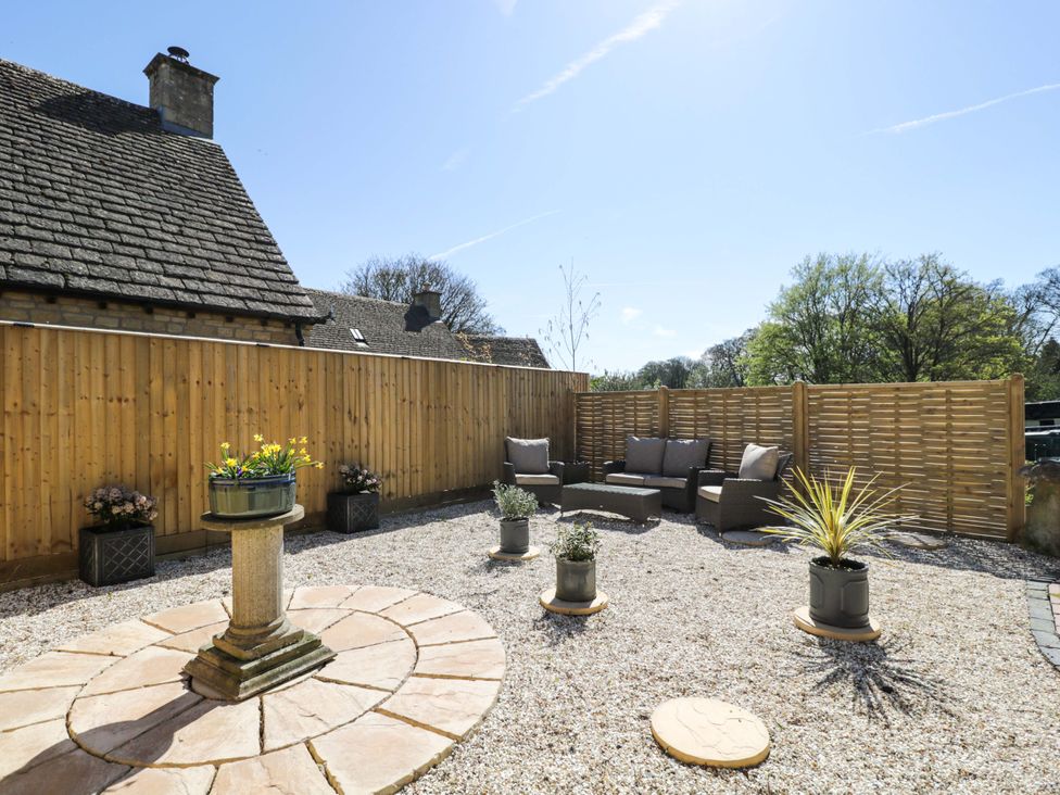 A garden with seating area and planters at Paddock View Stow-On-The-Wold