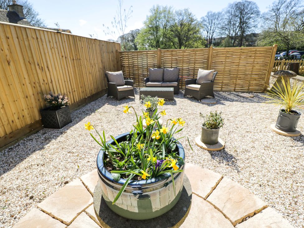 A garden with a seating area and planters at Paddock View in Stow-On-The-Wold